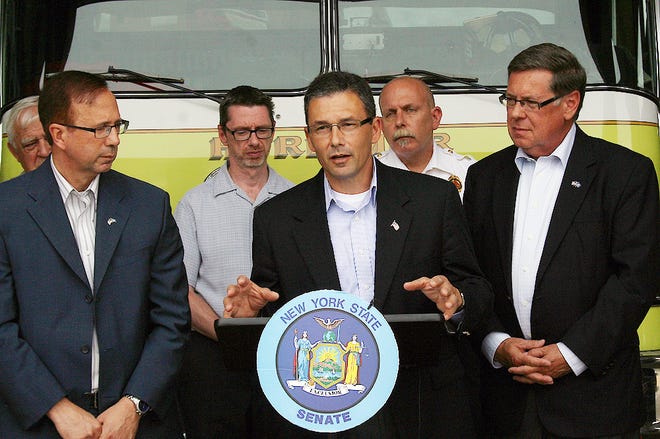Herkimer County Legislature Chairman Vincent Bono, center, addresses the media during a press conference at the Herkimer Fire Department on Friday afternoon. State Senators Joseph Griffo, left, and James Seward announced a multi-prong strategy to assist local businesses and residents recover and rebuild from the flooding that ravaged 15 counties. Pictured in the back row from left are Herkimer Village Trustee Harold Stoffolano, Herkimer Mayor Mark Ainsworth and Herkimer Fire Chief John Spanfelner.