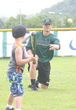 Mohawk Valley DiamondDawg Dalton Herrington pitches a tennis ball to Luke Lawton during a game at the final session of the DiamondDawgs' youth baseball camp Thursday.