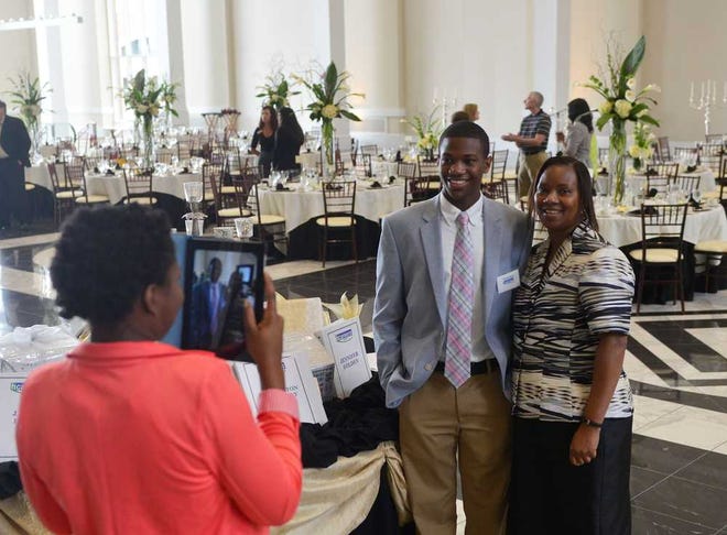 Candice Mumphrey, left, takes a photo of her brother, Charleston Mumphrey, center, and mother, Carol Mumphrey during a Hospitality Career Academy Luncheon and celebration at The Classic Center on Friday, July 12, 2013, in Athens, Ga.  (Richard Hamm/Staff) OnlineAthens / Athens Banner-Herald