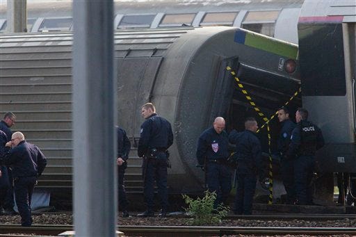 Police officers investigate on the site where a train derailed at a station in Bretigny sur Orge, south of Paris, Saturday, July 13, 2013. France's transport minister says human error did not cause a train derailment outside Paris that left six dead. Frederic Cuvillier said Saturday that around 30 people were still considered injured. In all, nearly 200 people sustained injuries in the initial accident, when four train cars slid toward the station, some falling over. (AP Photo/Thibault Camus)