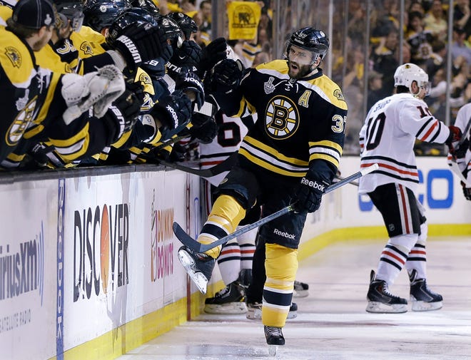 Bruins center Patrice Bergeron celebrates his goal with teammates on the bench during the third period in Game 4 Stanley Cup Finals against the Chicago Blackhawks. Bergeron signed a new contract with the Bruins on Friday.