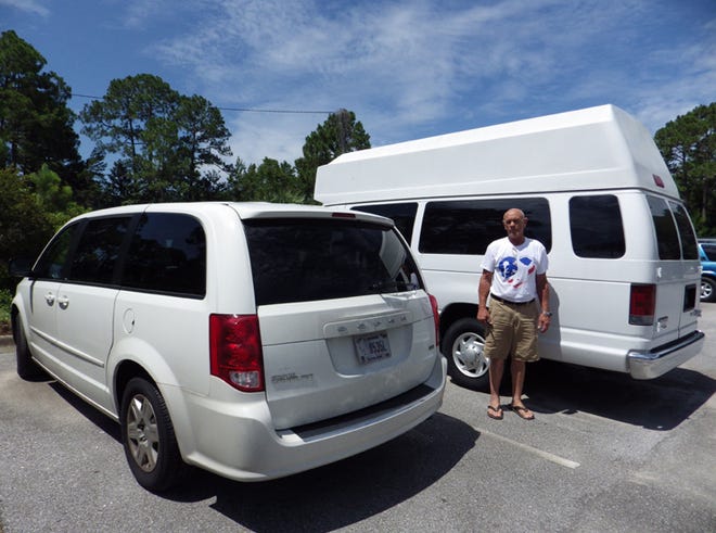 Dave Tainsh stands with the vans Hearts for Military Heroes will use to transport veterans to medical appointments.
