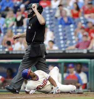 The Phillies' Ben Revere writhes in pain after fouling a ball off his foot in the 11th inning of the first game of Saturday's doubleheader. Revere broke his right ankle on the play.