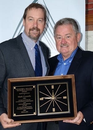 Mark Connelly (left) receives the Mitchell Connor award from Mike Connor.