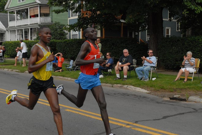 SARA TRACEY / Observer-Dispatch 
Two of the Men's Open Elite Runners Julius Keter, left, and Wilson Kiprotich, round the corner of Whitesboro Street and Champlin Avenue during the Boilermaker 15K race on July 14, 2013.