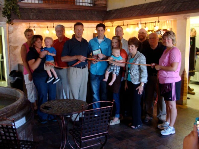 Chamber of Commerce President Dr. Tim Kaufman, center, holds the ribbon in front of the Frozen Spoon Cafe July 10 and gets ready to cut through as Frozen Spoon Cafe co-owner Michael Axelson, center, stands next to his wife, co-owner Whitney Axelson. Michael's Italian Feast Owner Veronica Axelson, far left with Whitney and Michael's son, is Michael's mother. The Frozen Spoon at 605 Ten Mile Creek officially opened July 5 with a grand opening scheduled for 2 p.m. July 19.