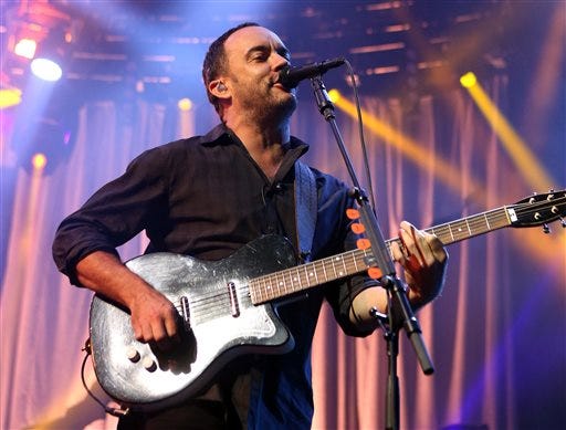 In this June 28, 2013 file photo, Dave Matthews of The Dave Matthews Band performs on stage at the Susquehanna Bank Center in Camden, N.J. Emily Kraus , one of Matthew's fans pulled over to give a stranded cyclist a ride and realized the hitchhiker was none other than Matthews. His bike had broken down Saturday, July 13, before a show in Hershey, Pa.