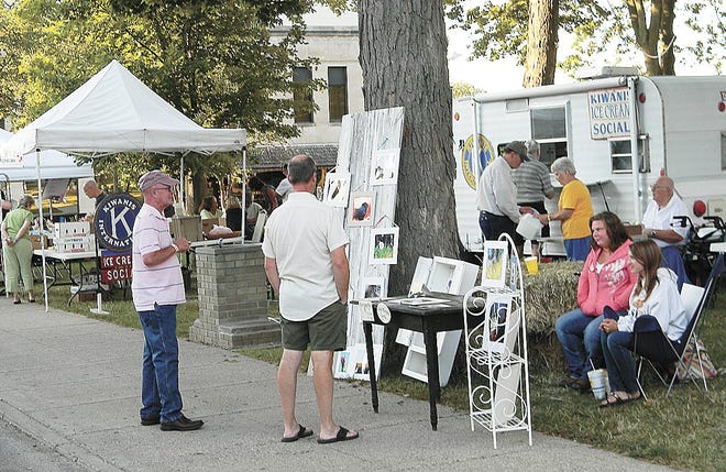 Visitors to last year's Hillsdale Street Fair look at artwork on display from one of several vendors. This year's festivall will be Friday and Saturday in downtown Hillsdale. The event is sponsored by the Hillsdale Business Association.