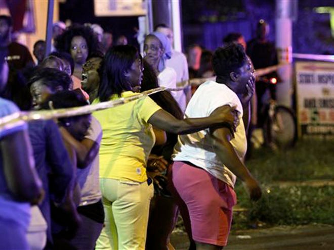 Family members react as they watch investigators at the scene of a fatal accident on Roosevelt Boulevard in the Olney section of Philadelphia on Tuesday evening July 16, 2013. Philadelphia police are investigating whether cars may have been drag racing when a mother and two young sons were struck and killed attempting to cross a busy highway. The woman's two other sons ages 4 and 5 are in critical condition. (AP Photo/ Joseph Kaczmarek)
