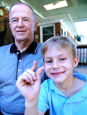 Liam Eubanks displays his grandfather Jerry’s long-lost wedding ring, which the youngster found playing in the mud behind the family home, 31 years after it was lost.