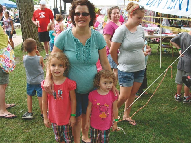 Evelyn Ward, 6, left, Tiffany Ward, center and Gretchen Ward, 3, right, all of Metamora, stand in line waiting for the kids tent to open at Old Settler’s Days June 22.