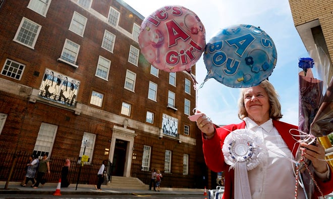 Margaret Tyler displays balloons for Britain's Prince William and his wife, Kate, in front of the Lindo Wing at St. Mary's Hospital in London. The royal couple is waiting to know their baby's gender.