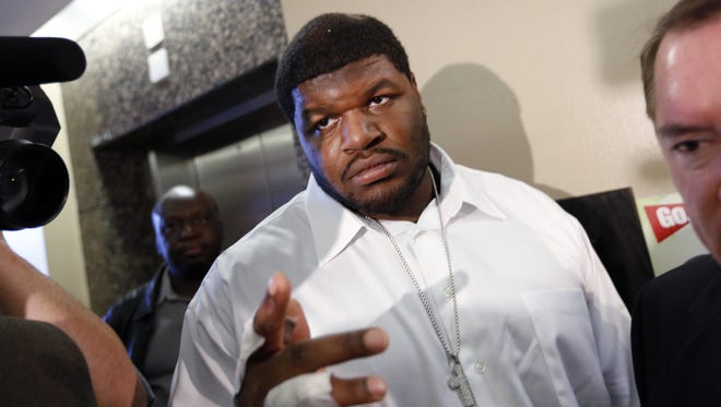 In this Dec. 18, 2012 file photo, Dallas Cowboys defensive tackle Josh Brent, center, and his attorney George Miller, obscured at right, leave court in Dallas. Brent says he is retiring from football as he faces trial for a fatal crash that killed a teammate. Brent's agent, Peter Schaffer, said Thursday, July 18, 2013, that the 25-year-old Brent was "taking care of his priorities." (AP Photo/David Woo, Pool, File)
