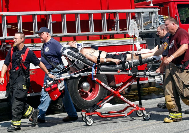 A firefighter is taken away on a stretcher while battling Thursday's 6 alarm fire on South Main Street in Uxbridge.