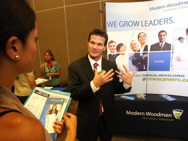 In this May 31, 2013 file photo, Adam VanDerbeck, a financial representative with Modern Woodmen Fraternal Financial, talks with Maria Tobon during the Employers Hiring Grads Forum held by Workforce Connection at the Klein Center at the College of Central Florida in Ocala.