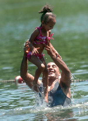 Yancy Rivera and his granddaughter Nashley Colon, 2, both of Willimantic, cool off Monday at Spaulding Pond in Norwich.