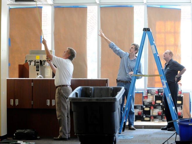 John Norwood (left) measures skylights while architect John Rees (center) and UNCW Director of Auxiliary Services Brian Dailey discuss plans for the new Port City Java being constructed in the campus' Randall Library on Thursday, July 18, 2013.