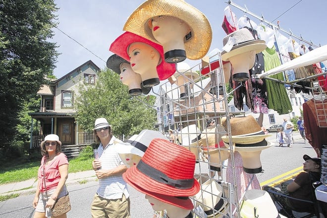 Cindy and Terry Hovencamp of Newburgh pass a display of hats as they make their way Sunday down Main Street in Rosendale during the hamlet's annual weekend street festival. The fair featured 73 bands on stages scattered throughout Rosendale, as well as vendors and lots of activities for kids. The event's planners are hoping to attract young volunteers to help carry on the tradition of the fair for next year.