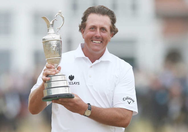 Phil Mickelson of the United States holds up the Claret Jug trophy after winning the British Open Golf Championship at Muirfield, Scotland, Sunday July 21, 2013. (AP Photo/Scott Heppell)