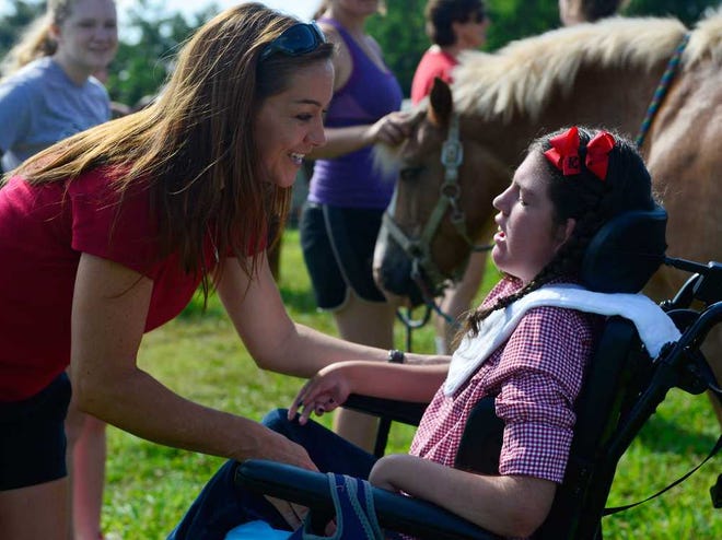 Kyla, right, who has cerebral palsy, visits with her nurse, JeAnna Damron during a therapy horse riding session at Butterfly Dreams Farms on Tuesday, July 23, 2013, in Watkinsville, Ga.   (Richard Hamm/Staff) OnlineAthens / Athens Banner-Herald