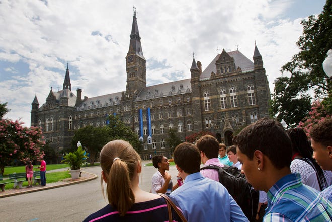FILE - Prospective students tour Georgetown University's campus in Washington, in this Wednesday, July 10, 2013, file photo. Grants and scholarships are taking a leading role in paying college bills, surpassing the traditional role parents long have played in helping foot the bills, according to a report from loan giant Sallie Mae. (AP Photo/Jacquelyn Martin, File)