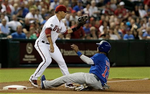 Chicago Cubs' Starlin Castro, right, slides safely into third base on a fly ball by teammate Anthony Rizzo as Arizona Diamondbacks' Martin Prado waits for a late throw in the first inning of a baseball game on Monday, July 22, 2013, in Phoenix. (AP Photo/Ross D. Franklin)