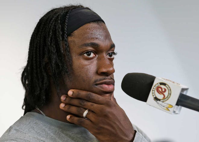 Washington Redskins quarterback Robert Griffin III listens to reporters questions during a news conference at the team's training facility in Richmond, Va. Wednesday, July 24, 2013. Griffin was recently cleared by doctors to begin practice at training camp which begins Thursday. (AP Photo/Steve Helber)