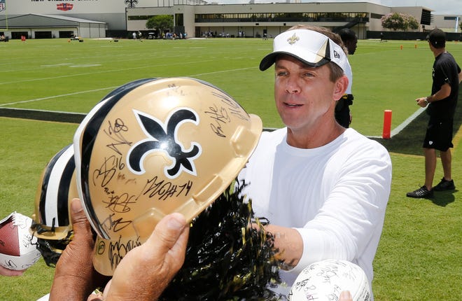 New Orleans Saints coachSean Payton signs autographs during a recent minicamp in Metairie.