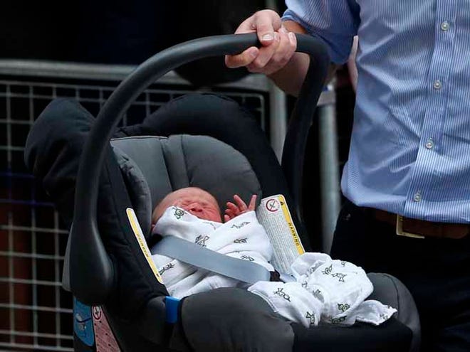 Britain's Prince William carries his son the Prince of Cambridge into a car Tuesday outside St. Mary's Hospital exclusive Lindo Wing in London, where his wife, Kate, the Duchess gave birth on Monday.