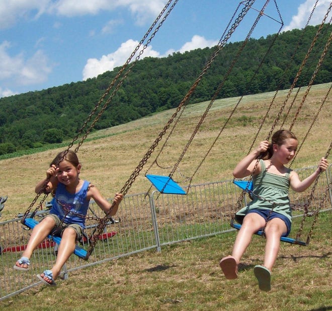 The Ontario Amusement rides were a big part of the fun at the Munnsville Volunteer Fire Department's 100th anniversary party the weekend of July 12, as, from left, Abby Lansing, 7, and Olivia Wolsey, 8, of Nelson, learn on the swings.