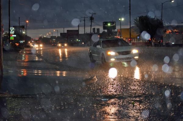 A car attempts to drive through flood waters on Ross Street on Wednesday night.