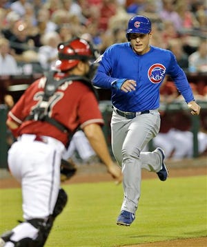 Arizona Diamondbacks catcher Wil Nieves, left, waits for the throw as Chicago Cubs' Anthony Rizzo scores on a hit by teammate Nate Schierholtz during the fourth inning of a baseball game on Wednesday, July 24, 2013, in Phoenix. (AP Photo/Matt York)