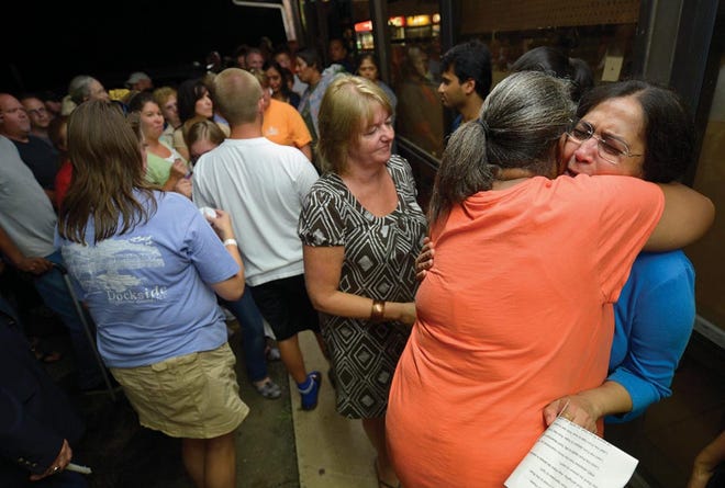 Rita Shah, right, cries as she is hugged at the candlelight vigil Thursday for her husband, Paresh Shah, who was killed during a robbery at his store, the Ken's Quickie Mart on Main Street in Gibsonville on Saturday night.