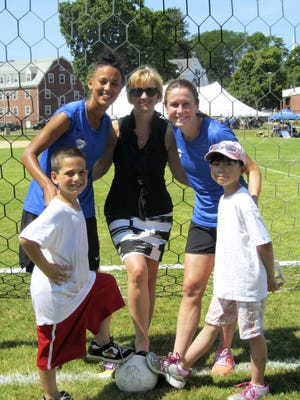 Joseph Princatta, 7, of Quincy poses with Boston Breakers forward Lianne Sanderson, Dependable Cleaners president Christa Hagearty, Breakers midfielder Heather O'Reilly and Gracie Ng, 9, of Quincy.