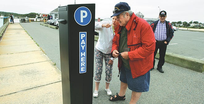 Pamela Kristofferson, left, helps Hugo Donatelli with the Onset Pier parking kiosk Thursday.