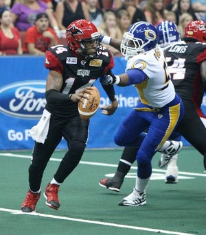 Jacksonville Sharks quarterback, Bernard Morris, rolls to his right to avoid a sack by Tampa Bay Storm lineman, R. J. Roberts, c during Saturday night's game in Jacksonville.