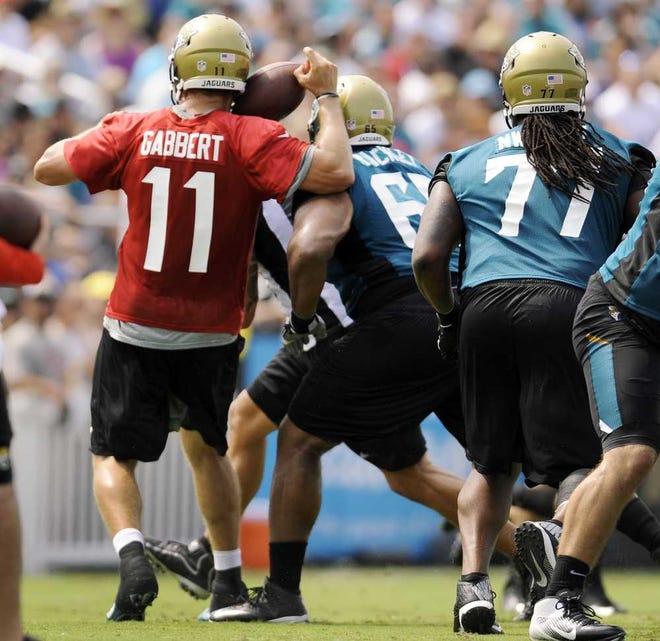 Jaguars quarterback Blaine Gabbert loses the ball after colliding with teammate Will Rackley during Saturday's training camp drills.  Bob.Self@jacksonville.com