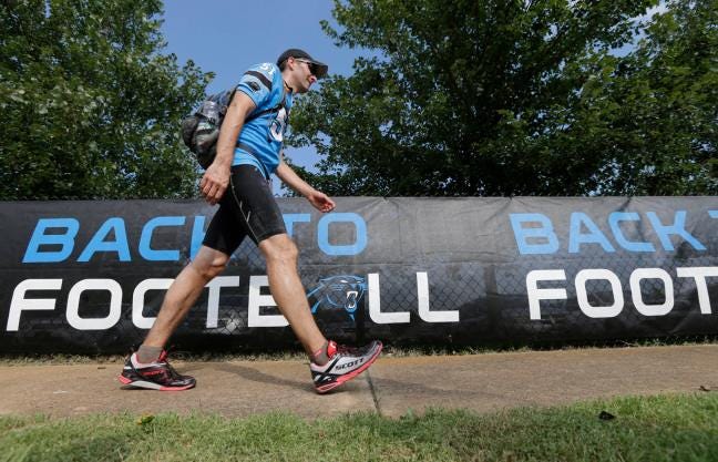 Carolina facilities manager Matthew Getz walks toward the practice field before the NFL team's first training camp practice in Spartanburg, S.C., Friday. Getz walked the 72 miles from Charlotte to Spartanburg, S.C., in memory of Jon Richardson, the team's former stadium president, who died of cancer earlier this month.