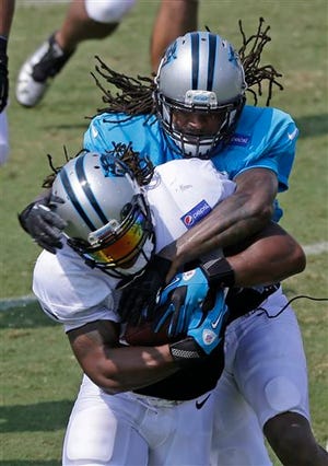 Carolina Panthers' DeAngelo Williams, front, is tackled by Charles Godfrey, back, during NFL football training camp practice in Spartanburg, S.C., Sunday, July 28, 2013.