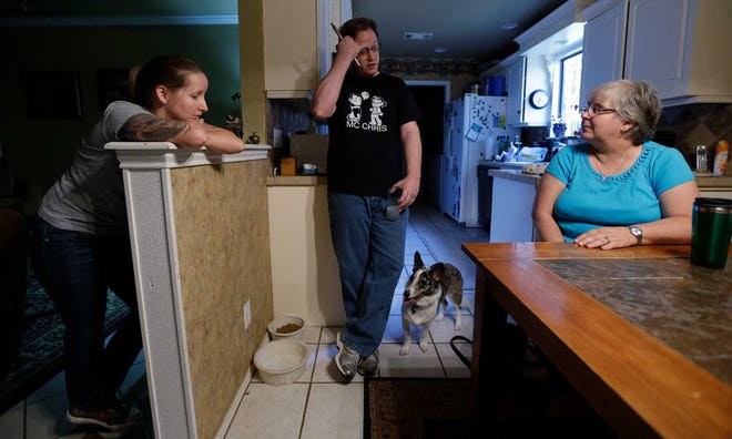 In this June 21, 2013, photo, Caitlin Baker, left, and brother, Jesse Baker, center, with their aunt, Lisa Conn, talk about their mother Debra Masters Baker in Austin, Texas. Debra Masters Baker was killed in her home Jan. 13, 1988. Her slaying remains unsolved but the family believes it might never have occurred had authorities not focused on the wrong man in a similar killing 17 months earlier. (AP Photo/Eric Gay)