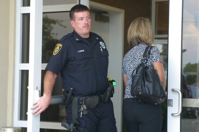 A police officer lets an unidentified woman into Bayside Savings Bank in Port St. Joe as federal regulators closed the bank.