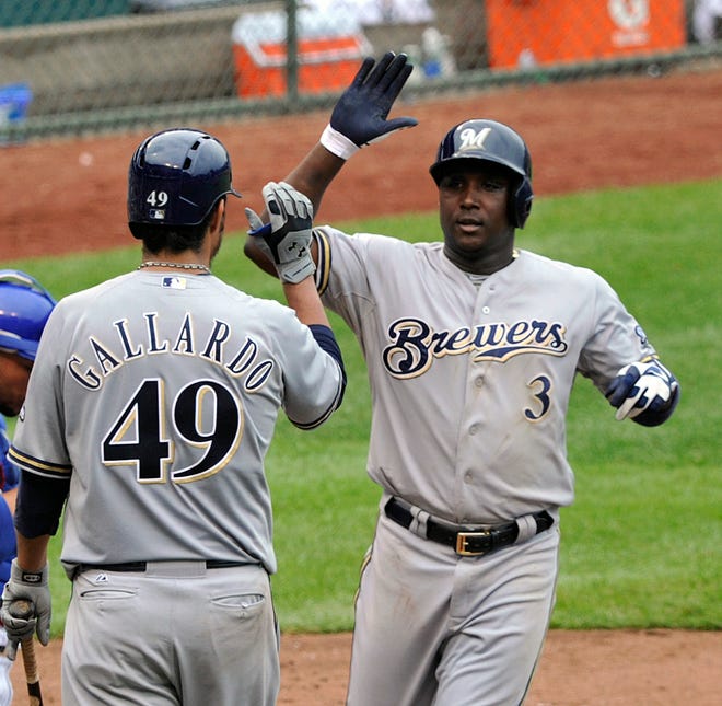 Milwaukee Brewers' Yovani Gallardo congratulates Yuniesky Betancourt (3) after his solo home run against the Chicago Cubs during the fifth inning of a baseball game Tuesday, July 30, 2013, in Chicago. (AP Photo/Jim Prisching)