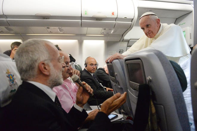 Pope Francis answers reporters questions during a news conference aboard the papal flight on its way back from Brazil, Monday, July 29, 2013. Pope Francis reached out to gays on Monday, saying he wouldn't judge priests for their sexual orientation in a remarkably open and wide-ranging news conference as he returned from his first foreign trip. "If someone is gay and he searches for the Lord and has good will, who am I to judge?" Francis asked. His predecessor, Pope Benedict XVI, signed a document in 2005 that said men with deep-rooted homosexual tendencies should not be priests. Francis was much more conciliatory, saying gay clergymen should be forgiven and their sins forgotten. Francis' remarks came Monday during a plane journey back to the Vatican from his first foreign trip in Brazil. (AP Photo/Luca Zennaro, Pool)
