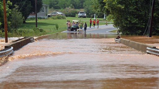 Residents watch as the floodwaters rise over McKay Rd. in Newton, N.C. Saturday, July 27, 2013. Parts of Catawba, Lincoln and Cleveland received up to a foot of rain Saturday as a result of a slow-moving rain system that brought flash floods and power outages. (AP Photo/The Charlotte Observer, Todd Sumlin) MAGS OUT; TV OUT; NEWSPAPER INTERNET ONLY