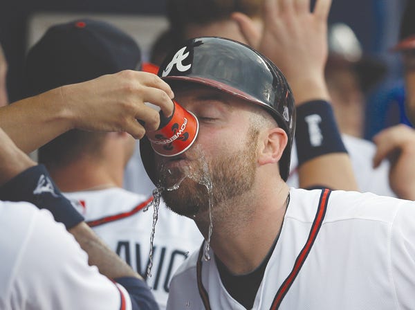 Atlanta's Brian McCann gets a drink from a teammate while celebrating his three-run homer against Colorado on Wednesday. The Braves won 9-0 for their sixth victory in a row. (John Bazemore | Associated Press)