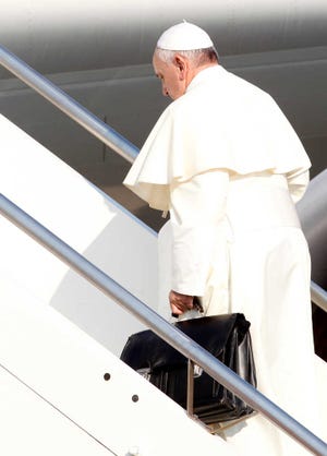 FILE -- In this July 22, 2013 file photo, Pope Francis holds a bag as he boards a plane at Rome's Fiumicino international airport for his first trip abroad as pontiff. Since his March 2013 election, Pope Francis has started a revolution in the Roman Catholic church that charmed millions and the mainstream media, as he goes about doing what he was elected to do: reform not just the dysfunctional Vatican bureaucracy but the church itself, using his own persona and personal history as a model. But the enthusiasm isn't necessarily shared across the board. Traditionalist Catholics - so coddled by Benedict XVI in his pursuit to reach out to Catholics attached to the old Latin Mass and opposed to the modernizing reforms of the Second Vatican Council - greeted Francis' election with concern and now have had their worst fears realized. Francis has spoken out both publicly and privately against such "restoratist groups" whom he accused of being naval-gazing retrogrades out of touch with the evangelizing mission of the church in the 21st century. (AP Photo/Riccardo De Luca)
