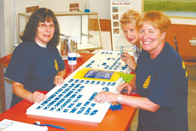 Yvonne Lafrinere (left), Jacqueline Tolstyka (back) and Marilyn Reichenberg (right) work on the menu board for the Rotary Club's food building Wednesday in preparation for the Cheboygan County Fair.