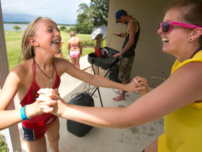 Camp Corral camper Katharine Pedroza, 9, of Orlando, left, dances with counselor Hailey Davis to a a country music tune at 4-H Camp Ocala in the Ocala National Forest Thursday afternoon. The camp hosted 144 kids this week. Camp Corral, sponsored by Golden Corral restaurants, has doubled in size to 18 camp locations in 14 states this year. The camp's mission is to give a meaningful and fun camp experience for children whose lives have been affected by a parent's military disability or injury or death.