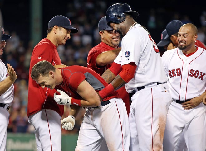 Boston Red Sox's Stephen Drew, bent over left, celebrates with David Ortiz, middle, Shane Victorino, far right, and other teammates after Drew hit an RBI walk-off single in the 15th inning to win a baseball game 5-4 against the Seattle Mariners at Fenway Park in Boston Wednesday, July 31, 2013.