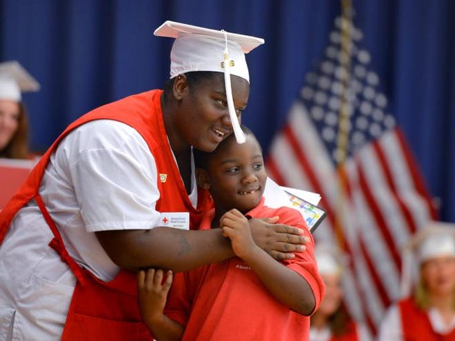 Whitney Williams gets a hug from her son, Ahmad Newell, 6, during a graduation ceremony at Alta Vista Elementary School on Thursday. Fourteen single moms graduated from a seven-week free course taught by American Red Cross that qualified them as Certified Nursing Assistants.
